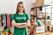 © Krakenimages.com - Young chinese woman wearing volunteer uniform standing with arms crossed gesture at charity center