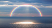Dusk Rainbow Concept - Beautiful Landscape With Multi Colored Calm Sea With Rainbow At Dusk