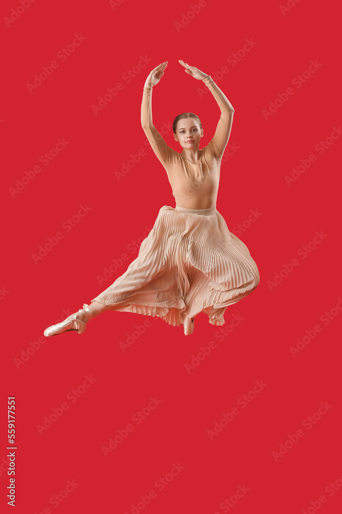 Female ballerina jumping on red background