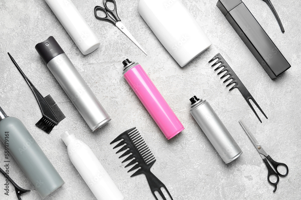 Hair care products with combs on grunge background
