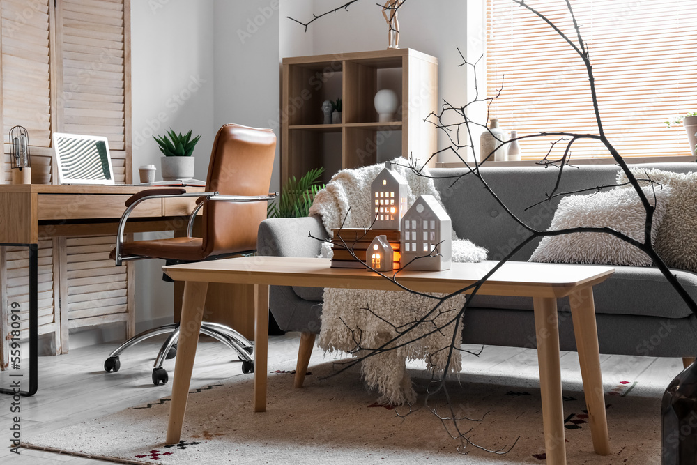 Interior of living room with candle holders, sofa and workplace