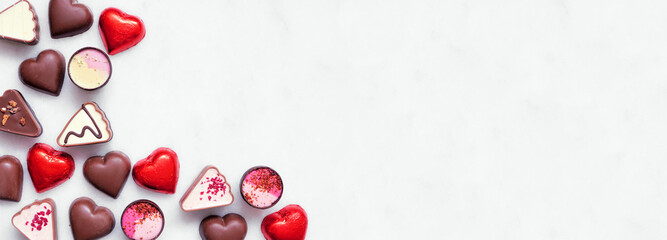 Aufkleber - Valentines Day chocolate corner border. Red and pink heart theme. Above view on a white marble banner background with copy space.