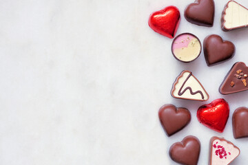 Aufkleber - Valentines Day chocolate side border. Red and pink heart theme. Top down view on a white marble background with copy space.