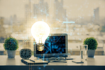 Poster - Computer on desktop in office with bulb icon hologram. Double exposure. Concept of idea.
