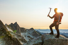 Portrait Of Male Hiker With Grappling Hook Standing On Mountain Against Clear Sky During Sunset