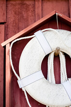 Life Ring Hanging On A Red Wooden Barn