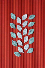 Canvas Print - faux leaves arranged on red corrugated paper