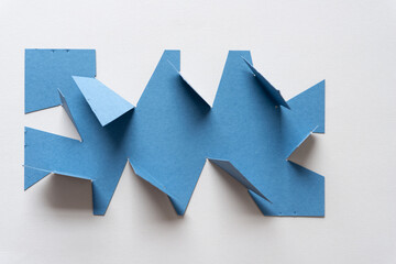 Wall Mural - blue card with cut and folded edges on blank paper