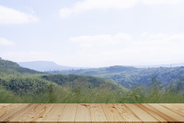 Background Nature Plant Tree with Empty Wood Table,Blank Counter Bar on Blur Green Glass Growth Forest with Mountain on Blue Sky,Mock Up for agriculture,Picnic,Environment,Spring Summer Season Concept