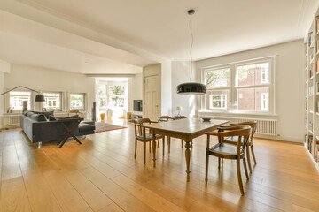 a living room with wood flooring and white walls in the background is a dining table, two chairs, an open fire place