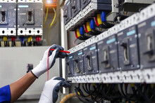 Electricity Or Electrical Maintenance Service, Engineer Hand Checking Electric Current Voltage At Circuit Breaker Terminal And Cable Wiring Check In Main Power Load Center Distribution Board.