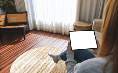 Mockup image of a woman holding digital tablet with blank desktop screen at home