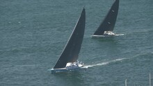 A Tracking Shot Of Two Yachts At The Start Of The Sydney To Hobart Yacht Race Sailing Down Sydney Harbour, Australia