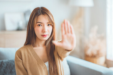 Young asian beautiful woman extend hand in stop gesture oppose against various violence. Warning expression with negative and serious gesture on the face.