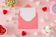 Leinwandbild Motiv St Valentines Day concept. Flat lay composition made of pink alarm clock, heart shaped saucers with candies and marshmallow on pastel pink background with envelope in the middle.