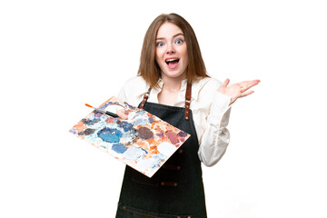 Wall Mural - Young artist woman holding a palette over isolated chroma key background with shocked facial expression