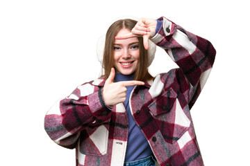 Sticker - Young pretty woman wearing winter muffs over isolated chroma key background focusing face. Framing symbol