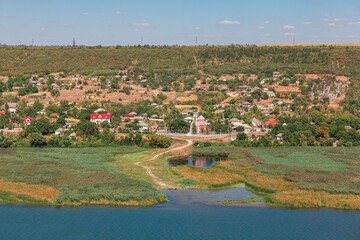 Green village situated at the riverside . Rustic coastal scenery  . Fishing village landscape