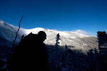 A Man Hikes The Boott Spur Link As A Storm Clears, Revealing Tuckerman's Ravine And The Summit Of Mt. Washington.