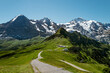 Scenic and sunny mountain landscape with a path crossing green alpine meadows near Jungfrau in Switzerland 