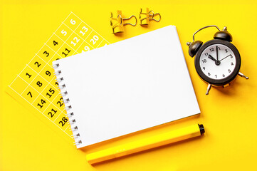 notepad, clock, calendar, paperclips.. copy space.top view