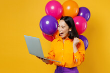 Happy Fun Young IT Woman Wear Casual Clothes Celebrating Near Balloons Holding Use Work On Laptop Pc Computer Do Winner Gesture Isolated On Plain Yellow Background Birthday 8 14 Holiday Party Concept