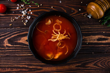 Sticker - Hot fresh tomato soup with fried onion rings in a bowl.