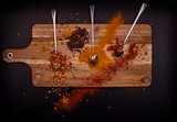 Fototapeta Na ścianę - Condiment with spoons on wood and black background.
