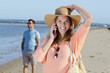© auremar - couple on the beach woman on cell phone