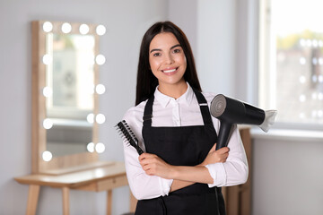 Canvas Print - Portrait of happy hairdresser with professional tools in beauty salon