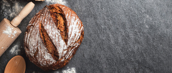 Poster - Whole loaf of fresh homemade bread on the table in the bakery top view