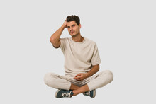 Young Caucasian Man Sitting On The Floor Isolated On White Background Tired And Very Sleepy Keeping Hand On Head.