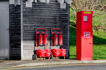 Powder fire extinguisher and red fire buckets for emergency use