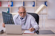 © Elnur - Old male doctor radiologist working in the clinic