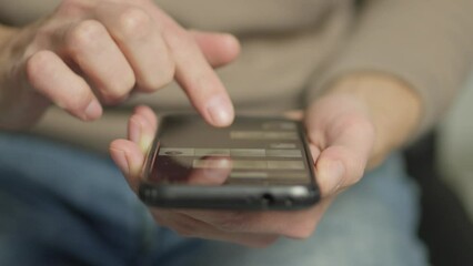 Aufkleber - A man's finger touches a monitor to scroll a page on a mobile phone. Viewing photos and documents in the smartphone library. A man in his hands uses a smartphone, turns pages.