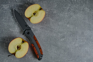 Wall Mural - Folding knife for survival and two halves of cut apple.