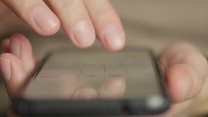 Aufkleber - A man's finger touches a monitor to scroll a page on a mobile phone. Viewing photos and documents in the smartphone library. A man in his hands uses a smartphone, turns pages.