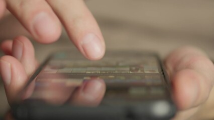 Aufkleber - A man's finger touches a monitor to scroll a page on a mobile phone. Viewing photos and documents in the smartphone library. A man in his hands uses a smartphone, turns pages.