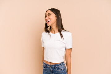 Young colombian woman isolated on beige background laughs and closes eyes, feels relaxed and happy.