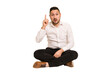 © Asier - Adult latin man sitting on the floor cut out isolated having an idea, inspiration concept.