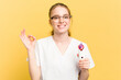 © Asier - Young beautician woman holding a facial cleaner isolated on yellow background cheerful and confident showing ok gesture.