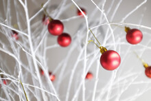 Close-up Of Red Christmas Baubles Decorated On White Branches At Home
