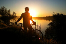 Cyclist Silhouetted Against The Sun Rising Over Lake Natoma - Orangevale, California.