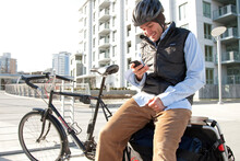 A Bike Commuter On An Extracycle Stops To Send A Text Message.