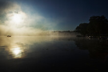 Silhouette Of Two Fishermen On Palmer Lake In, Michigan With Early Morning Fog.