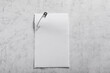 © New Africa - Sheet of paper attached with safety pin on grey textured background, top view