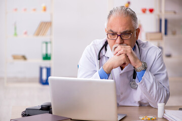 Sticker - Old male doctor working in the clinic