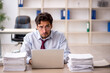 © Elnur - Young male employee and too much work in the office