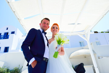 Wall Mural - Beautiful young couple bride and groom celebrate wedding on Santorini