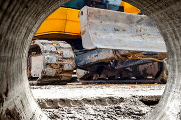 Wall Mural - Close-up mini excavator during the construction of a modern residential complex. Miniature construction equipment for working in cramped conditions.